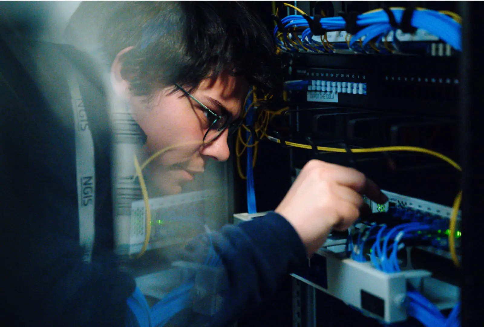 technician configuring network equipment in server rack