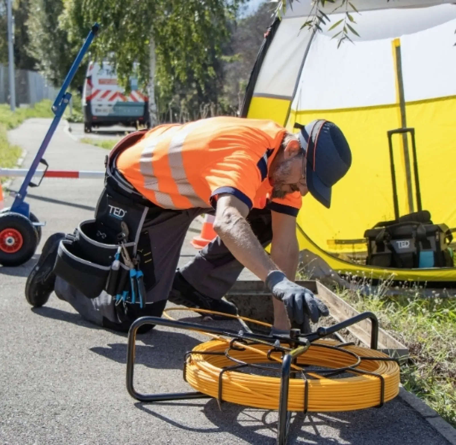 Techniker installiert bei einem Straßeneinsatz ein Kabel auf einer Trommel