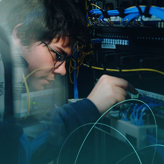 technician configuring network equipment in server rack